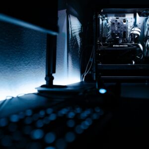 Dark, atmospheric shot of a high-end gaming PC setup in a minimalist room.